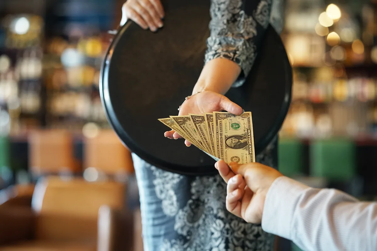 Restaurant server handling tips and gratuities